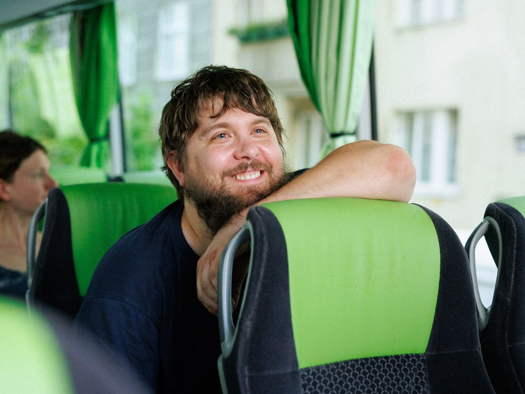 Ihr Partner für Bus mieten & öffentlichen Verkehr 11 Fahrgast sitzt lächelnd im Dr. Richard Reisebus_(c) Dr. Richard_Marcella Ruiz Cruz